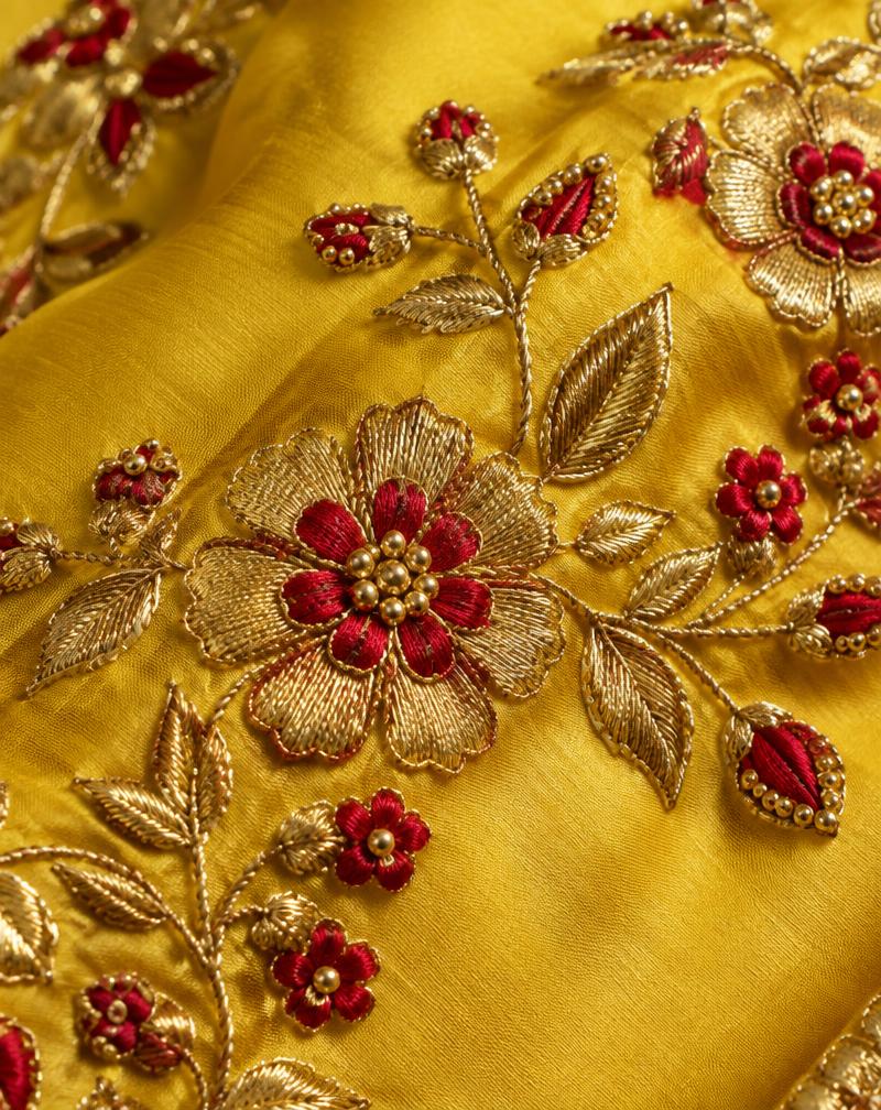 Yellow fabric with floral handwork, illustrating a custom garment detail
